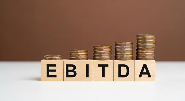 EBITDA letters on wooden blocks with increasing stacks of coins symbolizing financial growth and profitability in a neutral setting conveying a message of success and investment potential photo