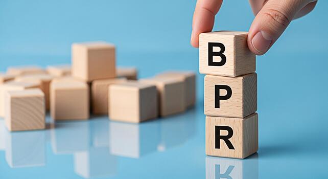Hand stacking wooden blocks with the letters BPR on a blue background representing Business Process Reengineering a management concept to improve efficiency and effectiveness in a corporate environmen photo