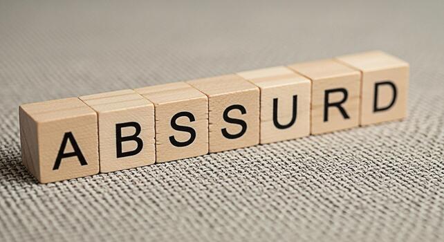 Wooden blocks spelling ABSURD on a textured surface conveying a sense of irony and questioning conventional thinking ideal for concepts related to humor philosophy and creative expression in a studio photo