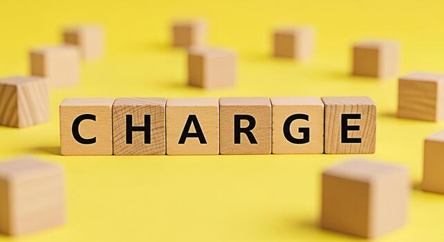 Wooden blocks spelling CHARGE on a vibrant yellow background symbolizing financial responsibility and the concept of fees costs and expenses creating a sense of urgency and importance photo