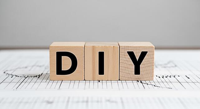 Wooden blocks spelling DIY sitting on a graph paper surface representing a doityourself project in a creative and minimalist setting conveying a sense of innovation and handson craftsmanship photo