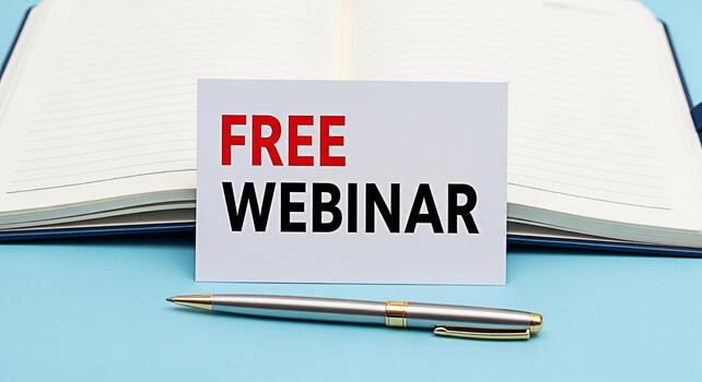 Informative card announcing a free webinar placed on an open notebook with a pen on a blue surface promoting online education and professional development opportunities creating an inviting and access photo