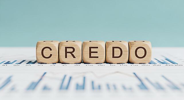 Wooden blocks spelling CREDO resting on a financial chart in a bright studio representing core values and beliefs in business and personal life conveying trust and reliability with a clean aesthetic photo