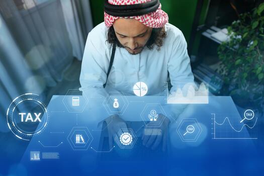 Man working on tax documentation with digital graphics in a modern office setting photo