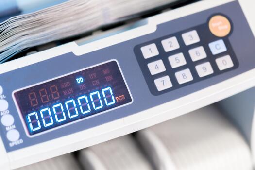 Counting machine displays numbers while sorting papers in an office setting photo