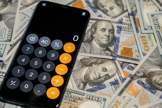 Calculator App on Smartphone Resting on Stack of Dollar Bills in a Well-Lit Setting With Focus on Financial Calculations photo