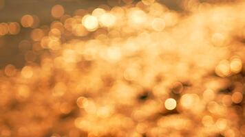 Sunlight water bokeh, shimmering golden reflections on the surface of calm water, creating a beautiful abstract background at sunset video