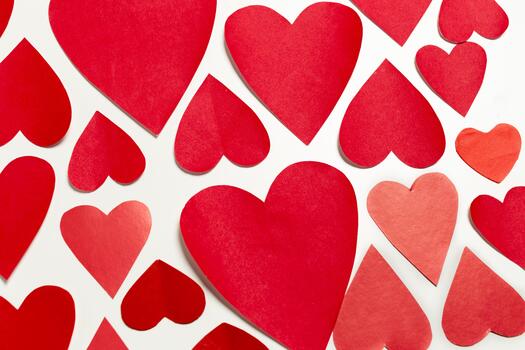 Various red heart shapes scattered over a light background for celebrations photo