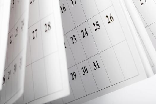 Calendar pages flipping in a close-up view showcasing daily numbers and dates photo