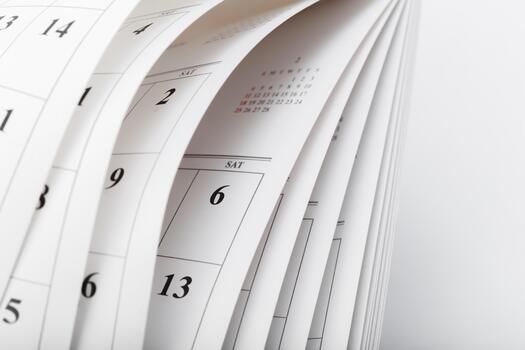 Calendar pages turning in a close-up view showing dates and days of the week photo