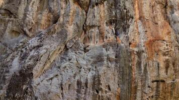 Drönare kamera stigande upp en ojämn och grov sten yta, avtäckande de detaljerad geologisk former och funktioner av en brant kanjon klippa video