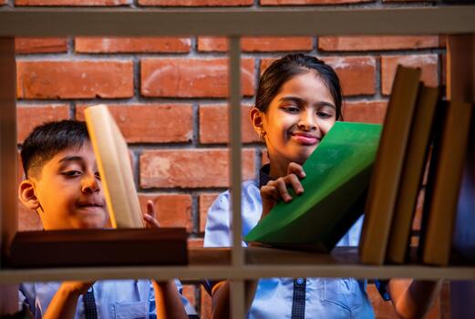 Indian Students in school uniforms browse and search for books in a library during study time photo