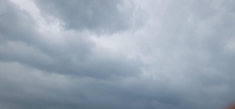 A view of a cloudy sky with a plane flying in it photo