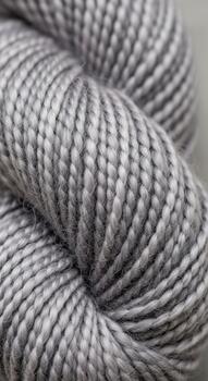 Close up view of a tightly wound skein of soft grey yarn with subtle variations in tone and texture photo