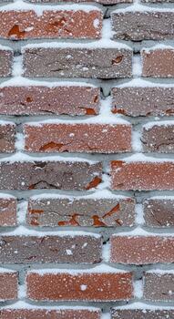 Close up textured view of weathered red and brown bricks with white mortar in a repeating pattern photo