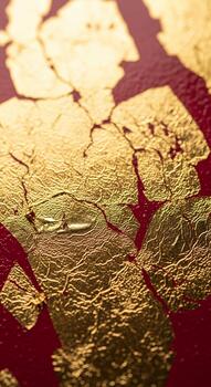 Close up textured view of cracked gold leaf applied to a deep red surface creating a luxurious and abstract pattern photo