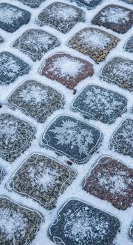 Close up view of cobblestones covered in a light dusting of snow creating a textured winter ground surface photo