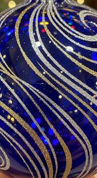 Intricate swirling patterns of glitter and sparkle adorn a deep blue surface creating a festive and luxurious design photo