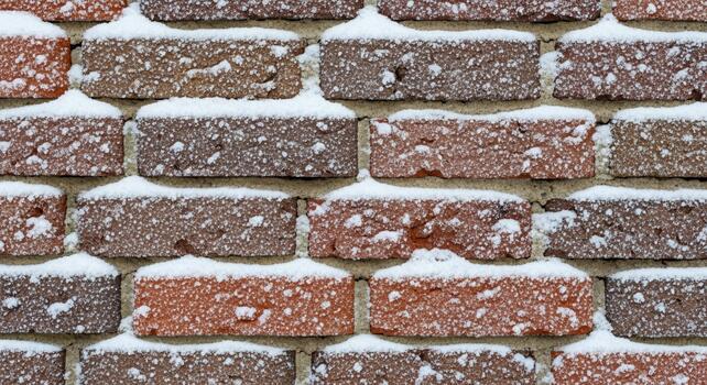 A close up overhead view of a brick wall covered in a light dusting of fresh snow creating a textured winter pattern photo