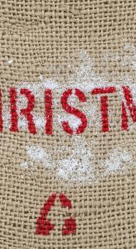 Rustic burlap texture with stenciled red christmas text and a decorative flourish photo