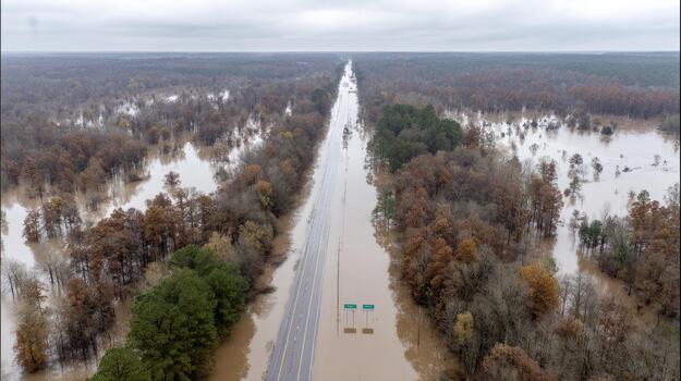 Flooded Highway Surrounded By Submerged Forest. Aerial View Of Natural Disaster Impact On Transportation photo