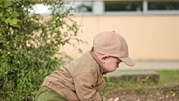 Lycklig pojke 2 år gammal löpning de lekplats. barn spelar och löpning medan gående på de gata. barn utveckling. video