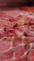 vertikal skärm stor belopp av lamm kött på visa i en slaktare affär. urval av kött i en Lagra. video