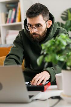 Man music producer or arranger using laptop and midi keyboard and other audio equipment to create music at home studio. Beat making and arranging audio photo