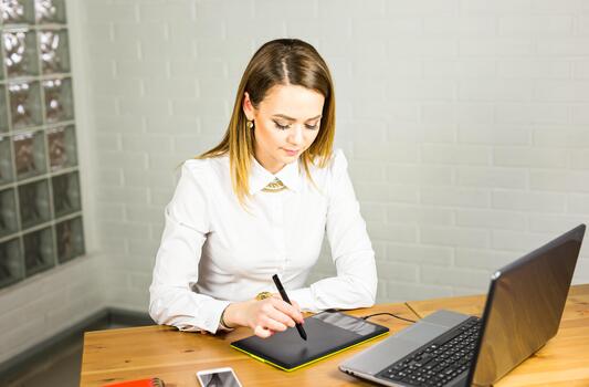 female designer using graphics tablet while working with computer. photo