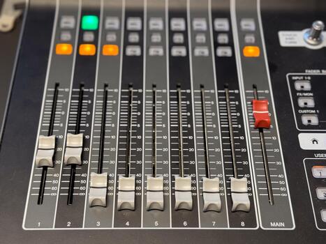 Audio mixing console with sliders and illuminated buttons. Sound engineering, music production and professional recording technology for creative audio control. photo