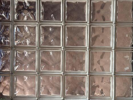 Pattern of glass blocks with reflective surface and textured transparency. Architectural design, geometric repetition and light abstraction in modern interior photo