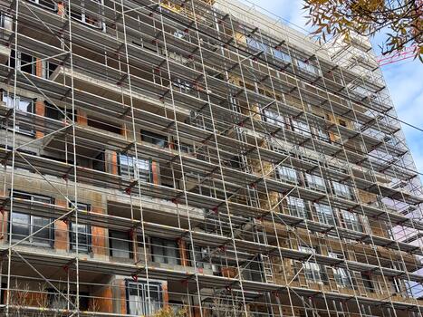 Scaffolding pattern on facade of urban construction site. Engineering precision, geometry and transformation in architectural development. photo