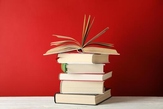 Stack of books against red background, space for text photo