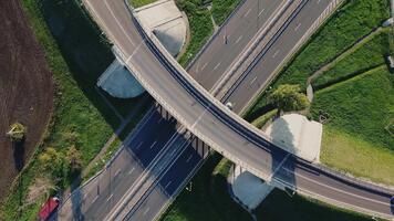 Aerial view of a busy expressway intersection with multiple lanes, showing cars and trucks maneuvering through exits and entrances during daytime. video
