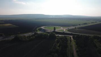 veículos navegar a interseção em uma ocupado via Expressa com cênico colinas dentro a fundo durante luz do dia. tráfego é contínuo com carros e caminhões fundindo. video