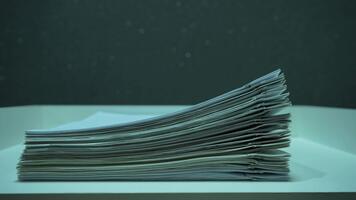 stack av företag dokument med metall papper clips visas och växer på en vit trä- skrivbord. närbild av kontor pappersarbete, rapporter och filer. video