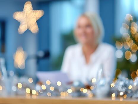Blurred background features woman holding document, surrounded by festive decorations and soft lights. This scene captures essence of setting financial goals for new year business context photo