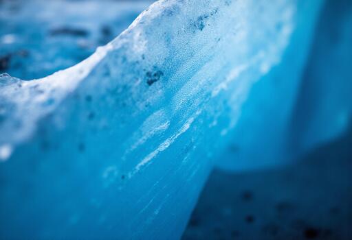 Abstract macro view of a deeply textured blue ice expanse with the cold color dominating the vertical composition photo
