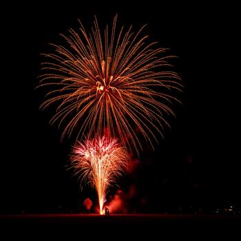 The intense red glow of several exploding shells creating a cascade of light and color photo