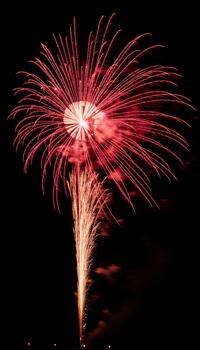 The intense red glow of an exploding shell creating a vibrant shower of light and color photo