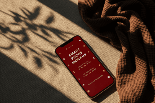 moderno smartphone visualizzazione rosso schermo con stilizzato testo su strutturato beige tessuto vicino Marrone sciarpa getto ombre su il sfondo per modello presentazione con caldo illuminazione psd
