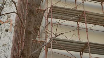 ett tömma konstruktion webbplats ställer ut byggnadsställningar för en blockera av lägenheter. arbetare förbereda för isolering och rehabilitering ansträngningar till förbättra byggnad effektivitet och estetik. video