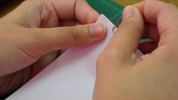 Close-up image featuring hands using a paperclip to organize sheets of paper on a tidy work surface, highlighting the importance of neatness in office tasks and study environments. video