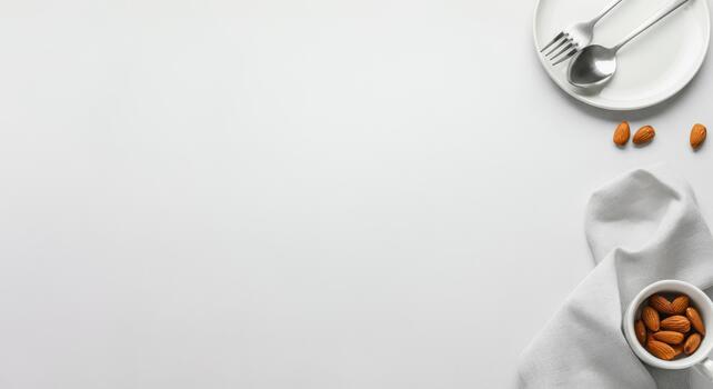 Minimalist table setting with utensils, almonds, and napkin on light background photo