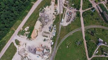 konstruktion zon i de fält nära de järnvägar. material för konstruktion och maskiner spridd förbi de webbplats. topp se. skog på de bakgrund. video