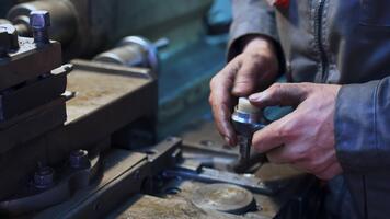 händer av svarvare tar två detaljer och fastnar dem tillsammans. svarvare framställning detaljer i hans verkstad. vändning svarv bakgrund. video