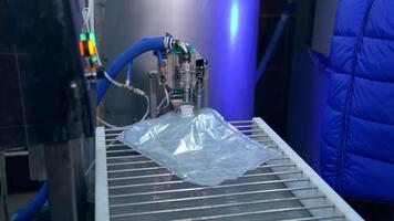 Transparent plastic bag being filled with juice through an opening. Factory worker smoothes out the bag for better filling of juice. video