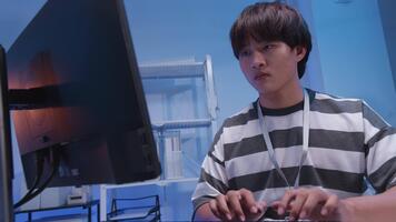 un' giovane maschio asiatico esso libero professionista e programmatore ingegnere Lavorando con computer tastiera del computer, digitando Software codici per applicazione sviluppo e sito web Rete sistema informazione dati nel camera. video