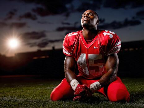 Football player showing determination on the field during sunset photo