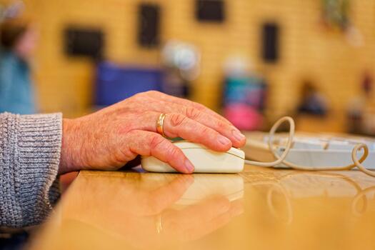 Senior hand using wired computer mouse symbolizing digital communication and modern work life photo